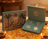 Set of coins in a decorative box on a table with Diwali decorations.