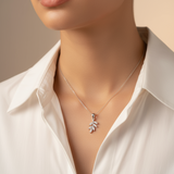 Close-up of a woman wearing a necklace and earrings with a neutral background