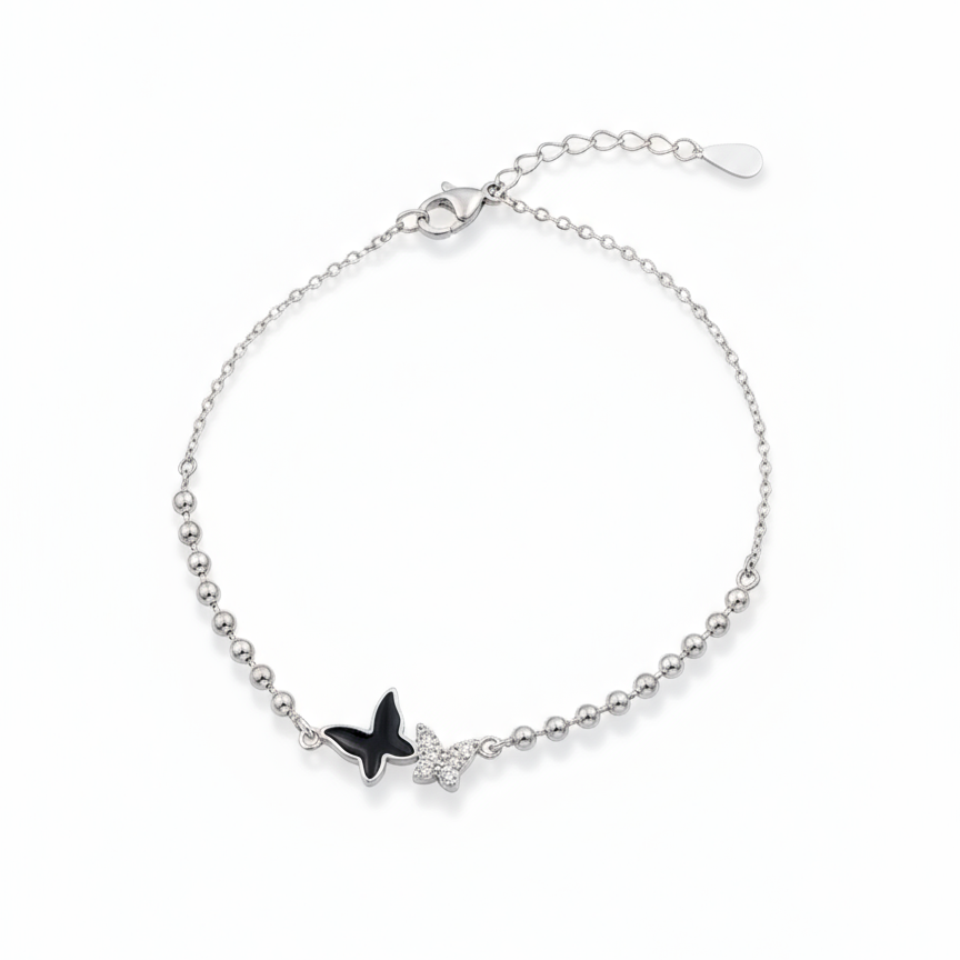 Silver bracelet with a black butterfly charm on a white background