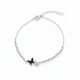 Silver bracelet with a black butterfly charm on a white background