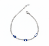 Silver bracelet with blue evil eye charms on a white background