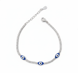 Silver bracelet with blue evil eye charms on a white background