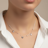 Necklace with heart and star pendants worn by a person in a white shirt against a neutral background