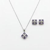 Silver jewelry set with purple gemstones on a white background