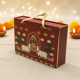 Decorative gift box with cow and floral design on a festive background with lights and candles.