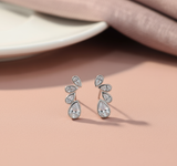 Pair of silver teardrop earrings on a pink surface