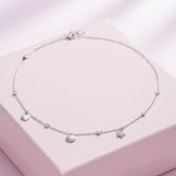 Silver bracelet with charms on a pink jewelry box