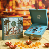 Decorative box with a peacock design on a table with lit candles and Diwali decorations.