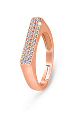 A rose gold-colored bar ring with a set of small stones across the top bar, presenting a sparkling and elegant appearance.