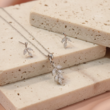 Silver necklace with a pendant on a textured beige surface