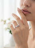 Close-up of a hand wearing a diamond ring with a blurred background